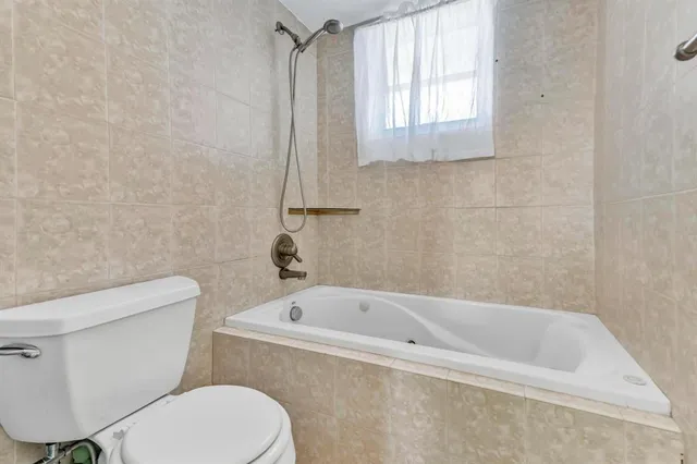 a white toilet sitting next to a bath tub