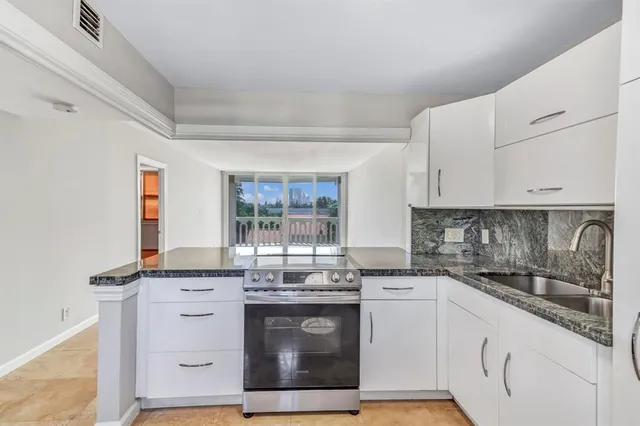 a kitchen with granite countertop white cabinets and white appliances