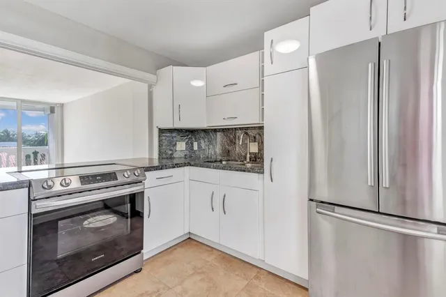 a kitchen with stainless steel appliances white cabinets and a refrigerator