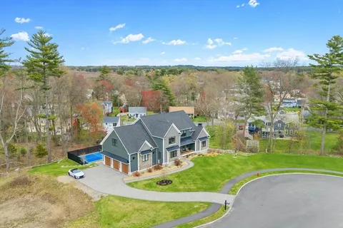 a aerial view of a house with a big yard and large trees