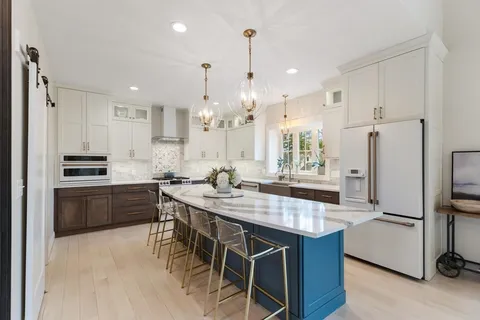 a kitchen with kitchen island granite countertop a sink stove and refrigerator
