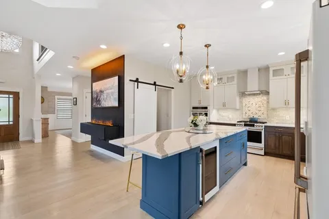 a large kitchen with stainless steel appliances granite countertop a sink stove and refrigerator