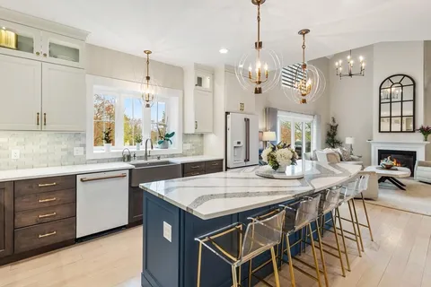 a kitchen with stainless steel appliances granite countertop a kitchen island a stove a table and chairs in it