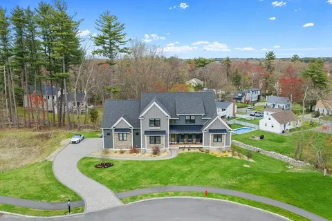 a view of a house with a big yard and large trees
