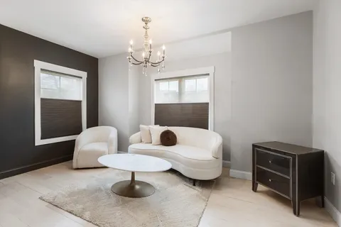a living room with furniture a chandelier and a window