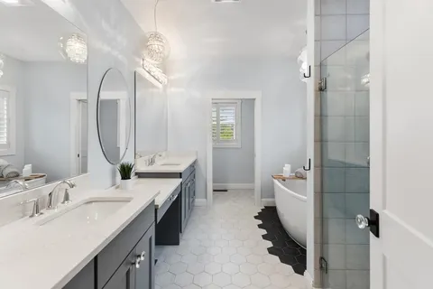 a spacious bathroom with a double vanity sink a mirror and a shower
