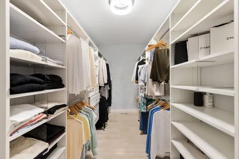 a view of walk in closet with clothes and shoes