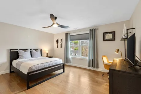 a bedroom with a bed tv and table