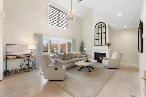 a living room with furniture a fireplace and a chandelier