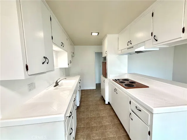 a kitchen with white cabinets and white appliances