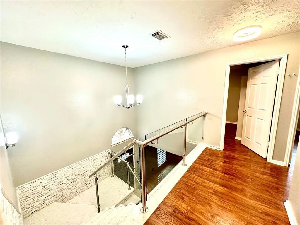 16918 Blend Stone Houston, TX 77084 - Photo 13 of 18 a view of a hallway with wooden floor and staircase