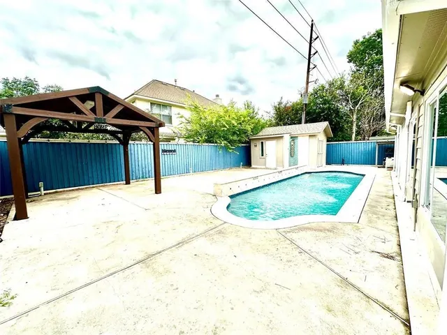 a view of a house with a small yard and wooden fence