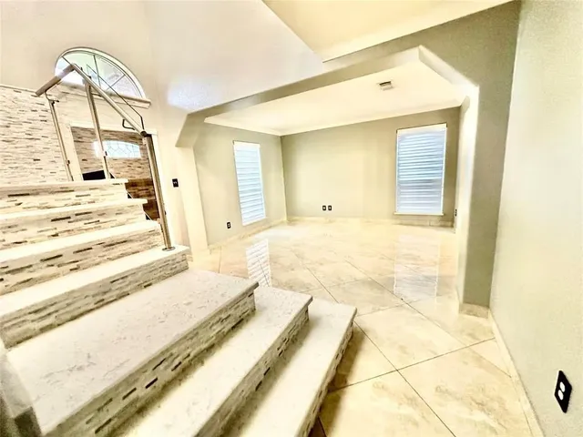 a view of a bedroom with wooden floor and white walls