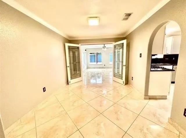 a view of a hallway with wooden floor and a bathroom