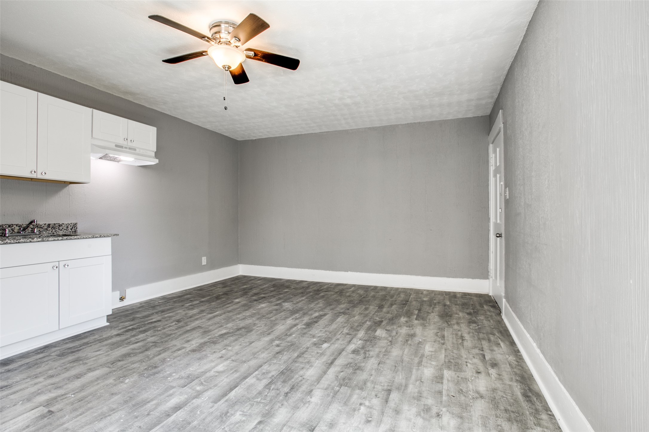 810 Maltby Street, Unit 2 Houston, TX 77011 - Photo 10 of 24 a view of an empty room and window a ceiling fan and wooden floor