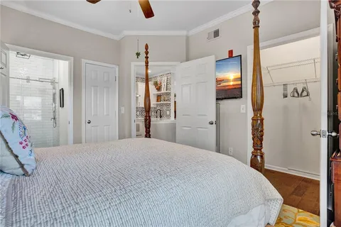 a bedroom with a bed and a flat tv screen on wall