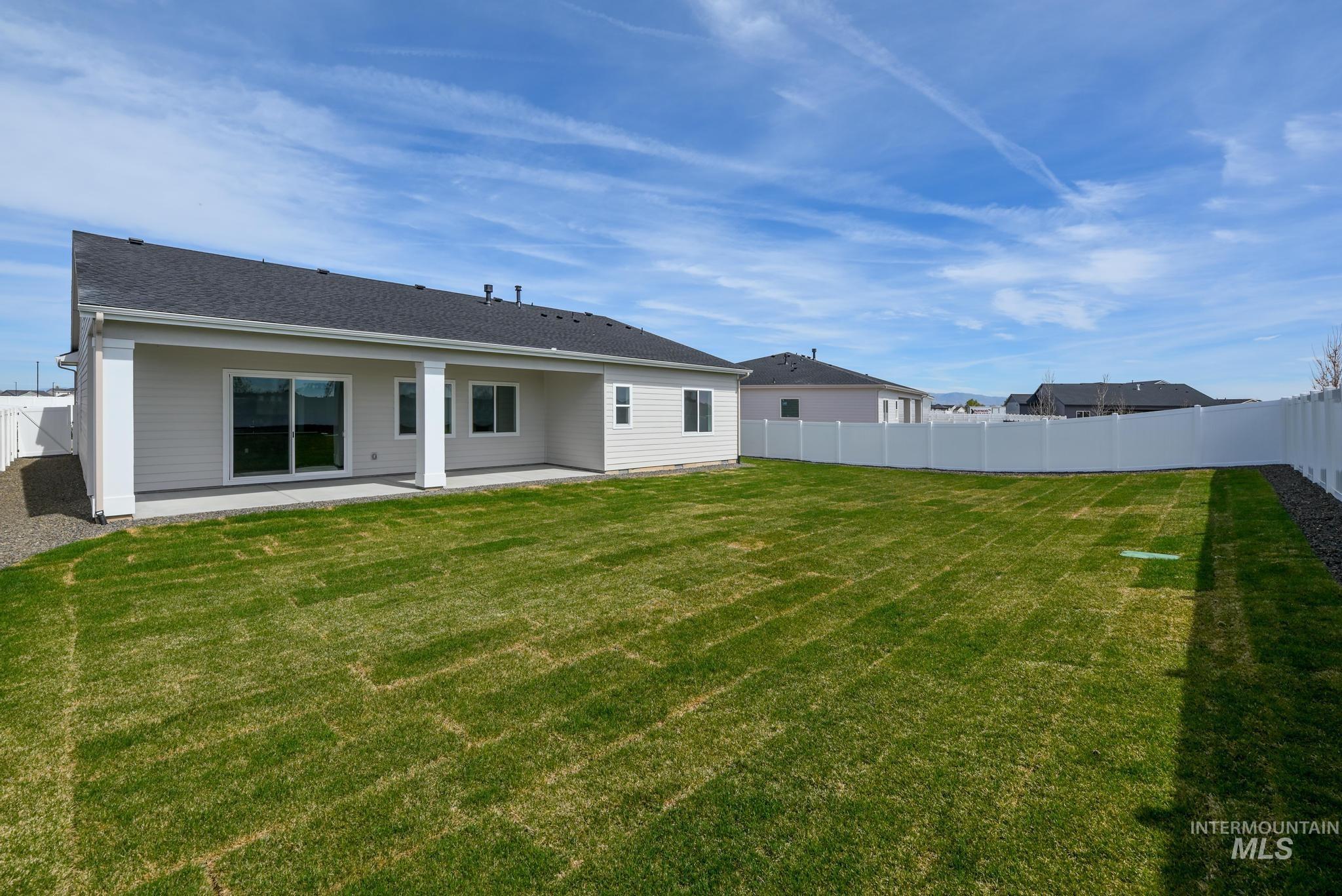 1195 West Switchgrass Drive Meridian, ID 83642 - Photo 13 of 22 Expansive backyard featuring a manicured lawn, full vinyl privacy fencing, and a covered patio