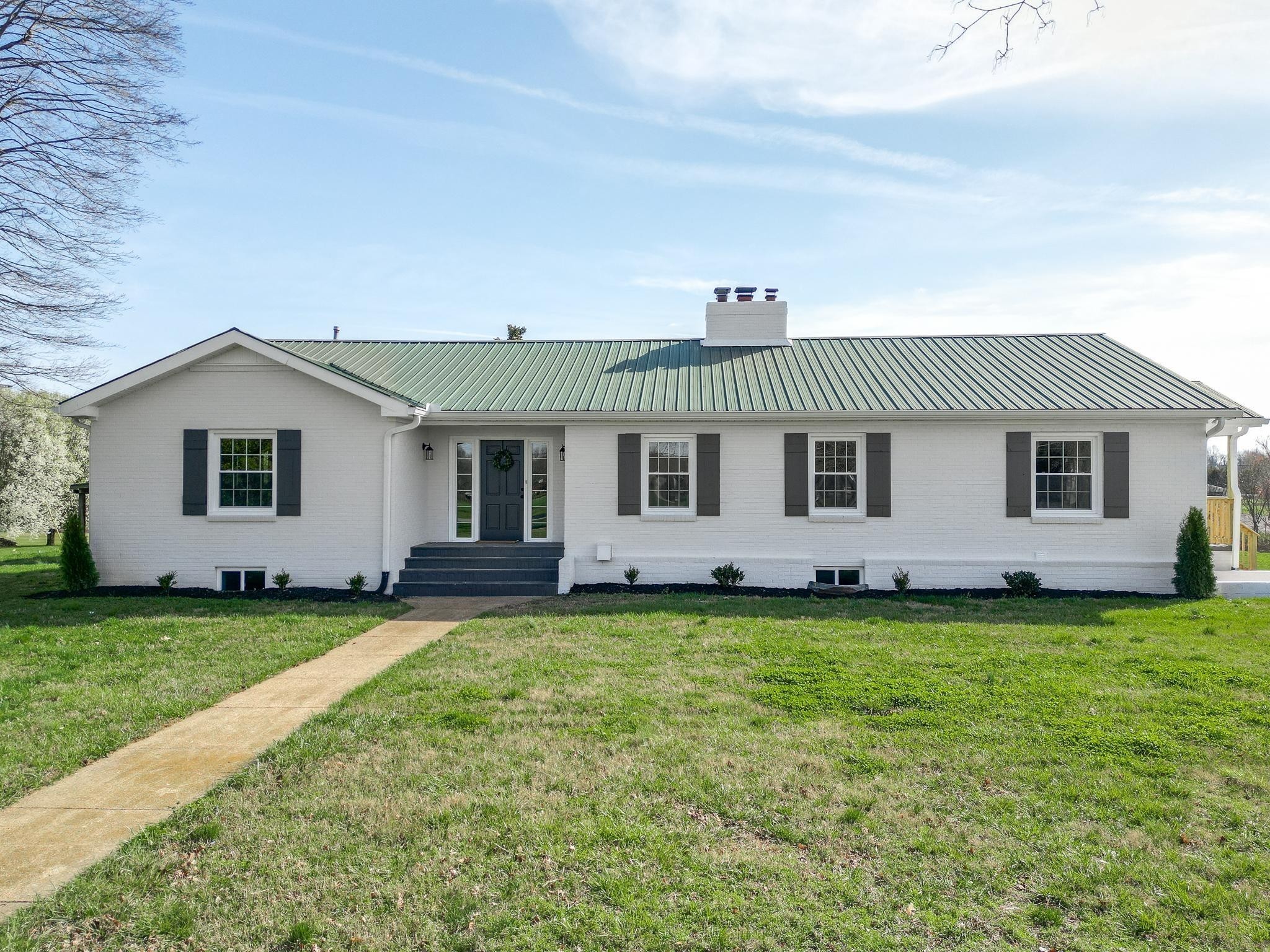 2771 Kinneys Road Cedar Hill, TN 37032 - Photo 2 of 45 a front view of a house with a garden