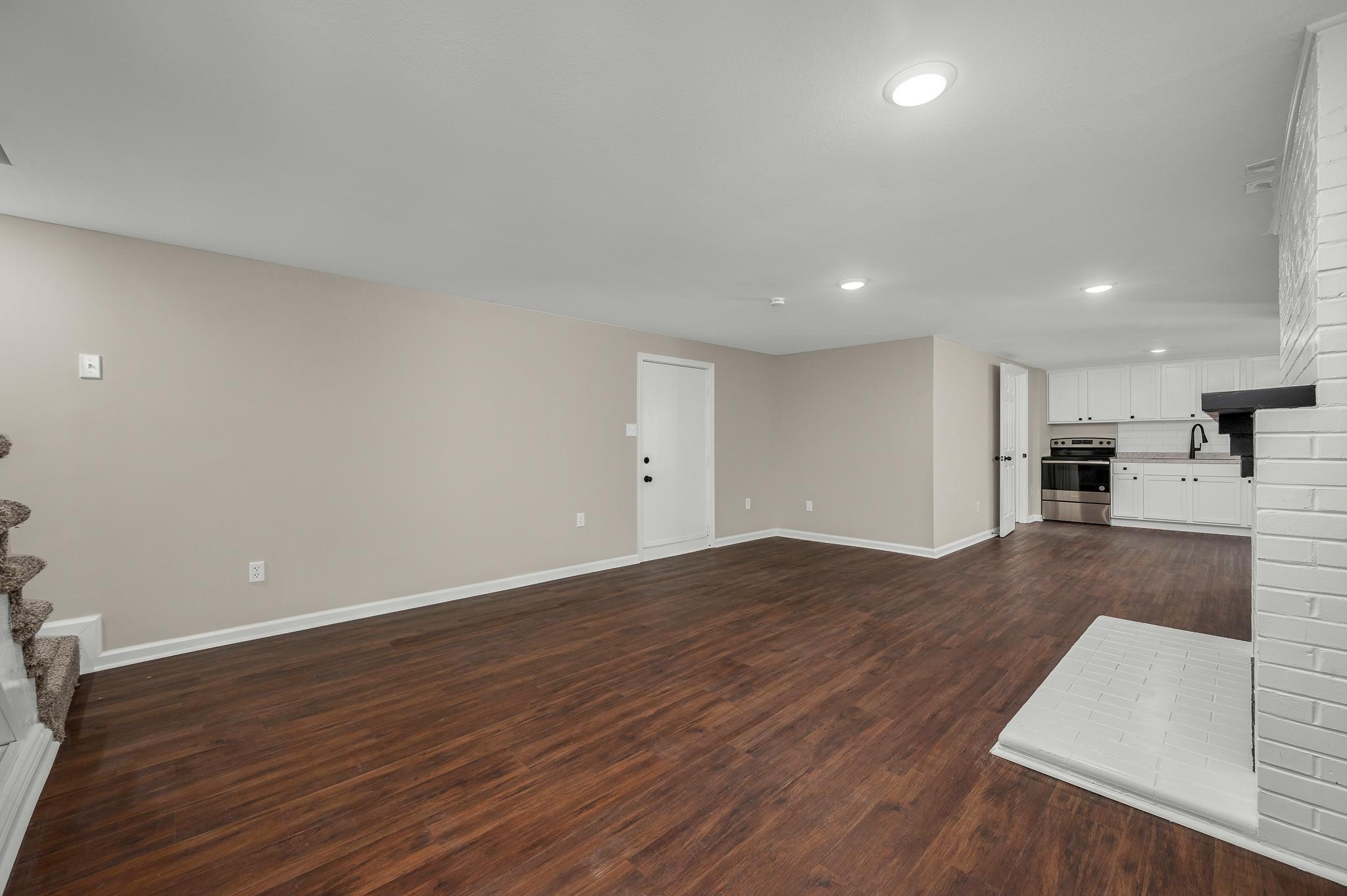 2771 Kinneys Road Cedar Hill, TN 37032 - Photo 29 of 45 an empty room with wooden floor and a kitchen