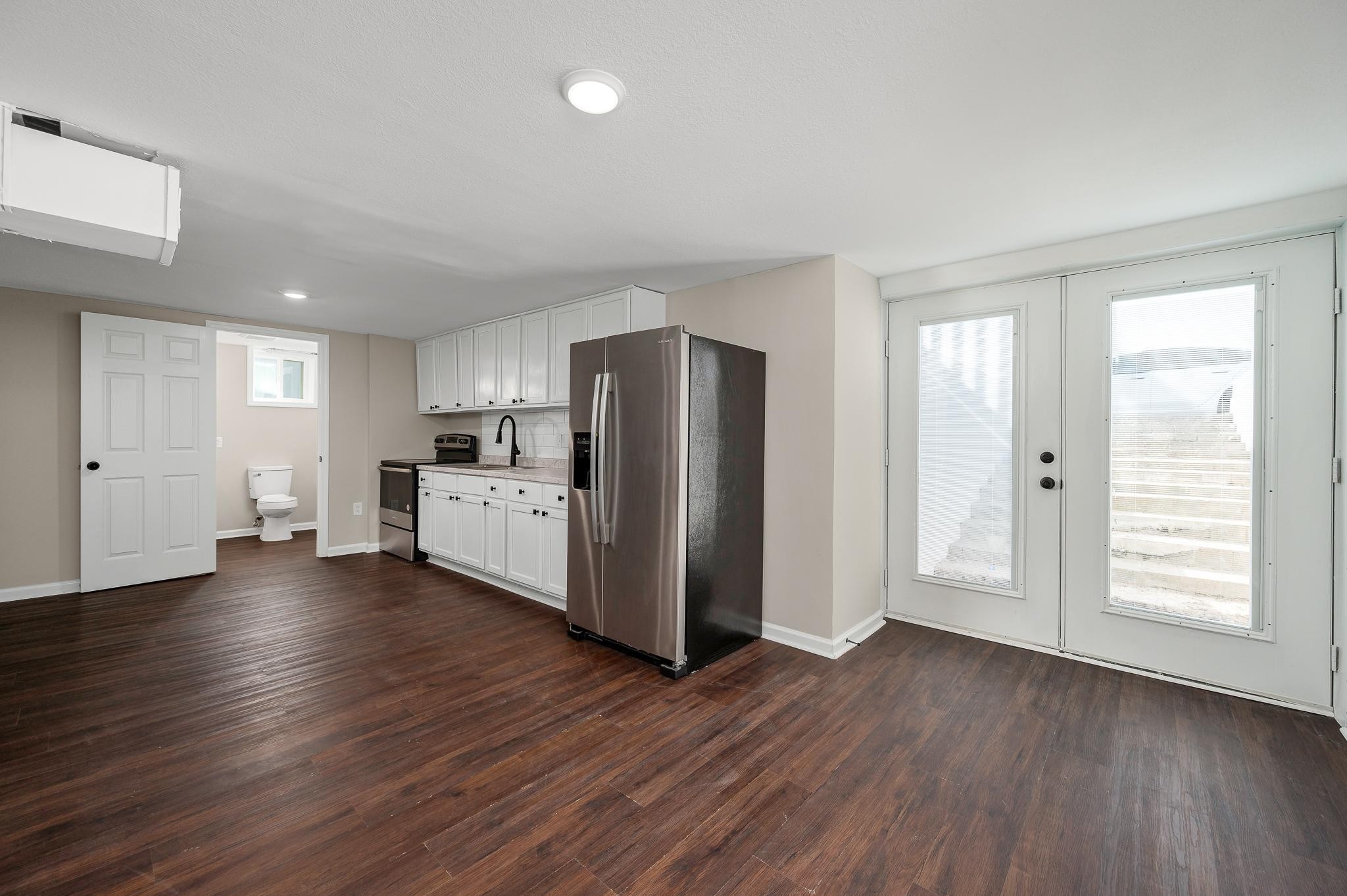 2771 Kinneys Road Cedar Hill, TN 37032 - Photo 31 of 45 a kitchen with stainless steel appliances wooden floors and white cabinets