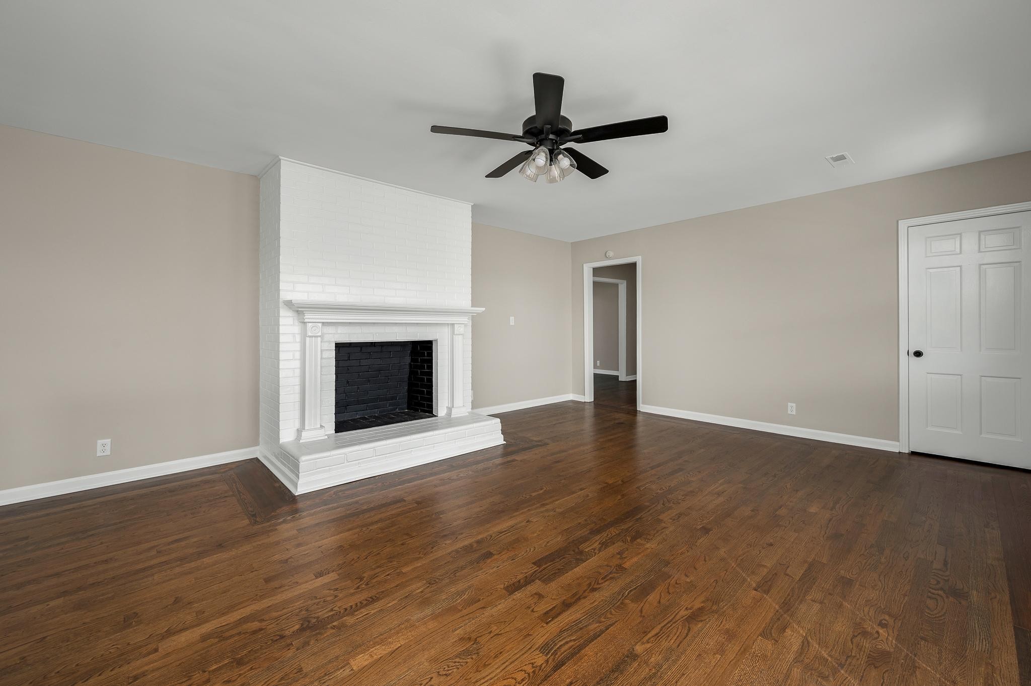 2771 Kinneys Road Cedar Hill, TN 37032 - Photo 10 of 45 a view of an empty room with wooden floor fireplace and a window