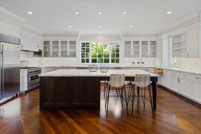 a kitchen with stainless steel appliances granite countertop a stove a sink a microwave and wooden floors