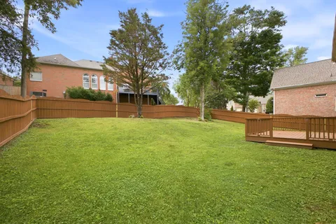 an aerial view of a house with a yard and lake view