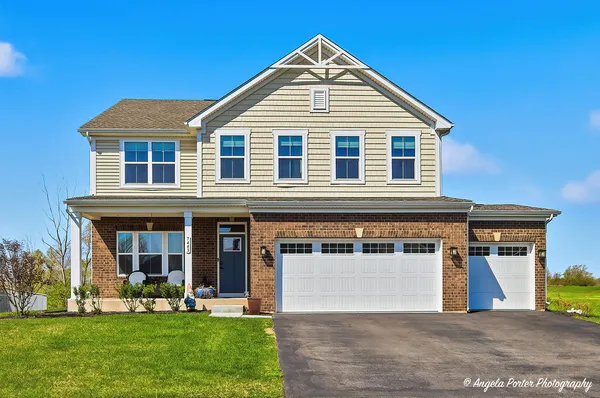 a front view of a house with a yard and garage