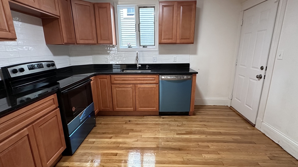 46 Theodore Street Boston, MA 02124 - Photo 11 of 32 a kitchen with stainless steel appliances granite countertop a stove a sink and a microwave