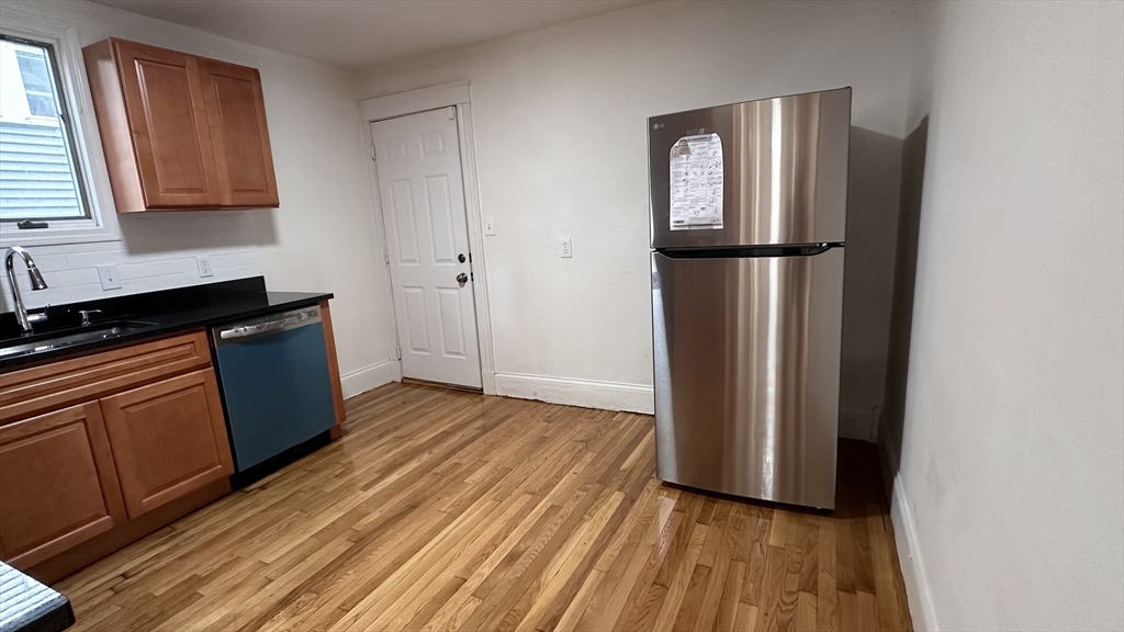 46 Theodore Street Boston, MA 02124 - Photo 12 of 32 a view of a kitchen with wooden floor and electronic appliances