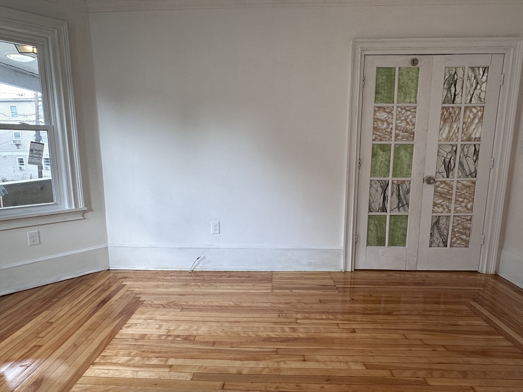 46 Theodore Street Boston, MA 02124 - Photo 18 of 32 a view of an empty room with wooden floor and a window