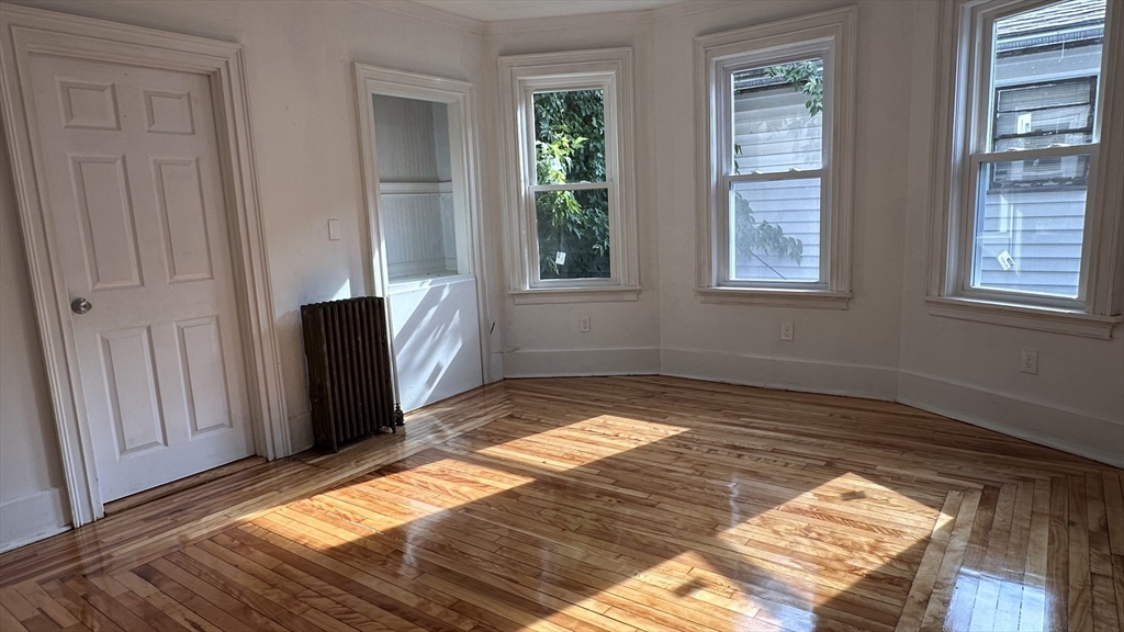 46 Theodore Street Boston, MA 02124 - Photo 22 of 32 a view of a bedroom with wooden floor and a window