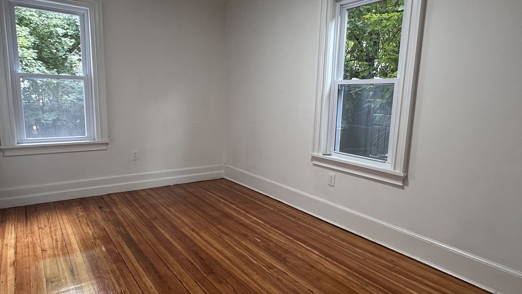 46 Theodore Street Boston, MA 02124 - Photo 27 of 32 a view of an empty room with wooden floor and a window