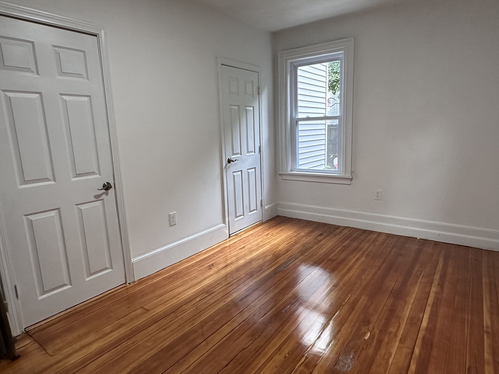 46 Theodore Street Boston, MA 02124 - Photo 29 of 32 a view of an empty room with wooden floor and a window