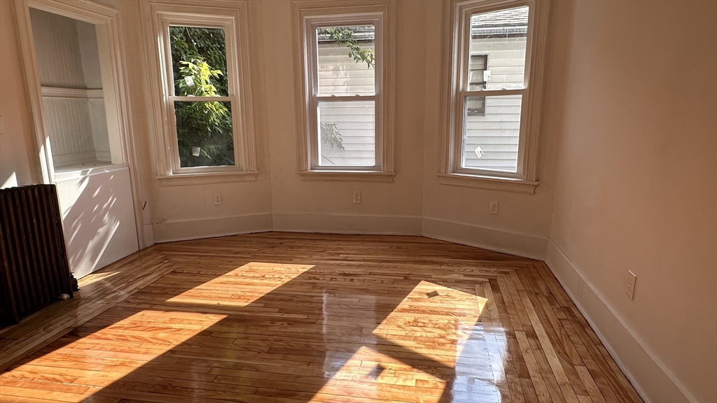 46 Theodore Street Boston, MA 02124 - Photo 3 of 32 a view of a bedroom with wooden floor and a window