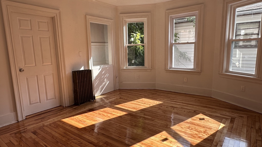 46 Theodore Street Boston, MA 02124 - Photo 4 of 32 a view of a bedroom with wooden floor and windows