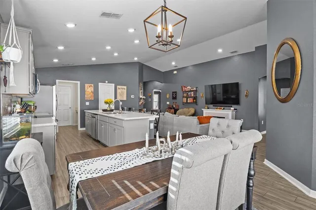 a living room with furniture a flat screen tv and kitchen view