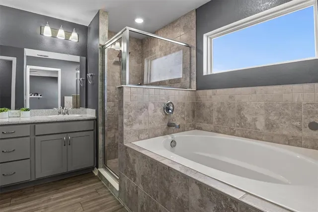 a bathroom with a bathtub and a double vanity sink