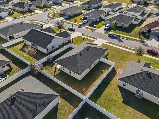 an aerial view of residential houses with yard