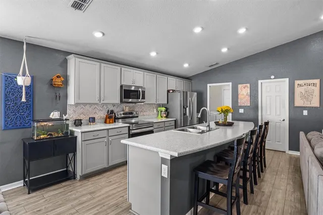 a kitchen with a dining table chairs and cabinets