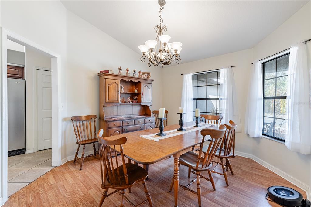 4530 Treasure Cay Road Tavares, FL 32778 - Photo 17 of 60 a view of a dining room with furniture a chandelier and wooden floor