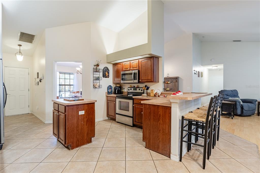 4530 Treasure Cay Road Tavares, FL 32778 - Photo 21 of 60 a kitchen with stainless steel appliances granite countertop a stove a sink dishwasher and a refrigerator