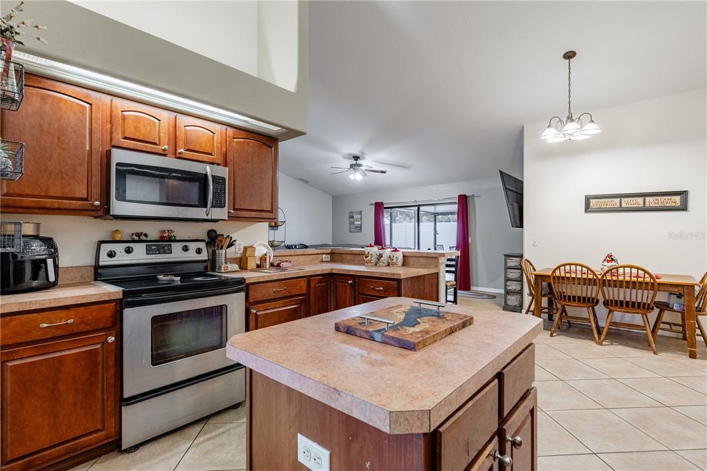 4530 Treasure Cay Road Tavares, FL 32778 - Photo 22 of 60 a kitchen with a stove a microwave and a dining table