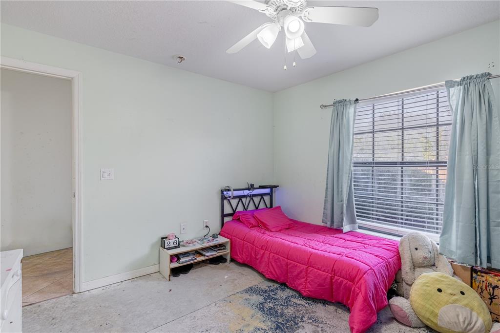 4530 Treasure Cay Road Tavares, FL 32778 - Photo 43 of 60 a bedroom with a bed and a chandelier