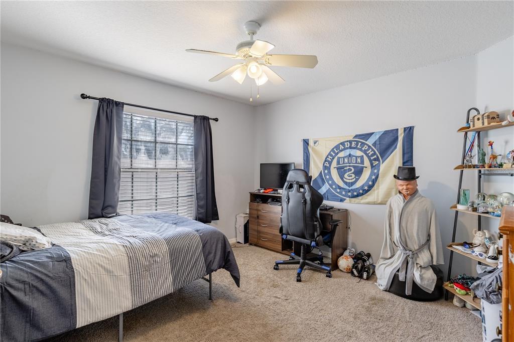 4530 Treasure Cay Road Tavares, FL 32778 - Photo 46 of 60 a bedroom with a bed and a chandelier