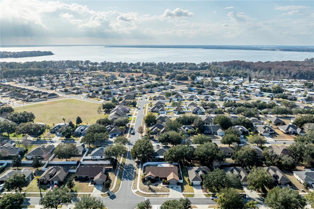 4530 Treasure Cay Road Tavares, FL 32778 - Photo 57 of 60 an aerial view of a city with lots of residential buildings and ocean view in back