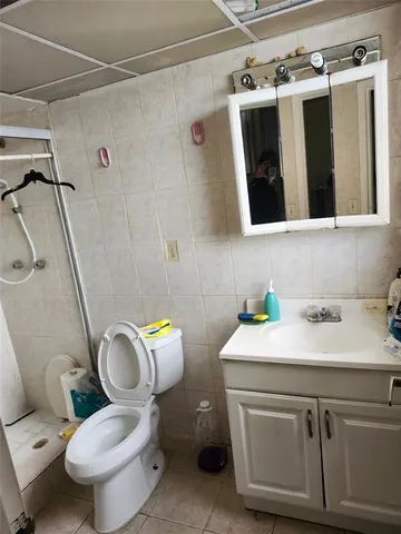 a bathroom with a sink a toilet a mirror and shower