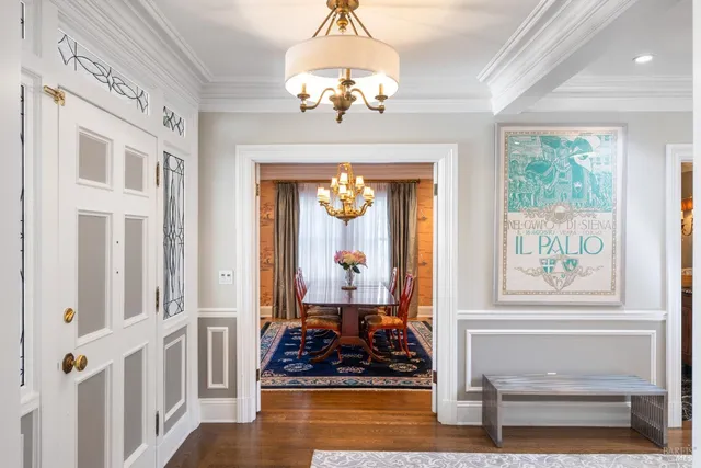 a kitchen with a stove a refrigerator and a dining table with wooden floor