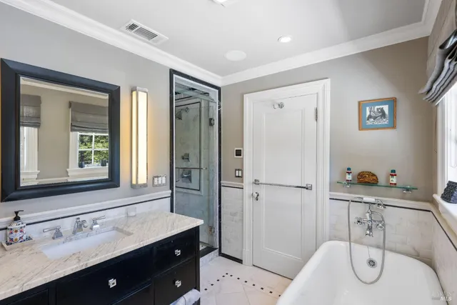 a view of a house with floor to ceiling windows and a table and chairs under an umbrella