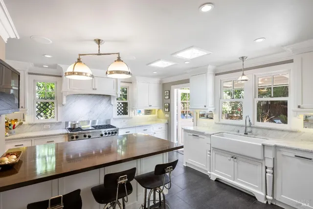 a kitchen with stainless steel appliances a stove a chimney and a counter space